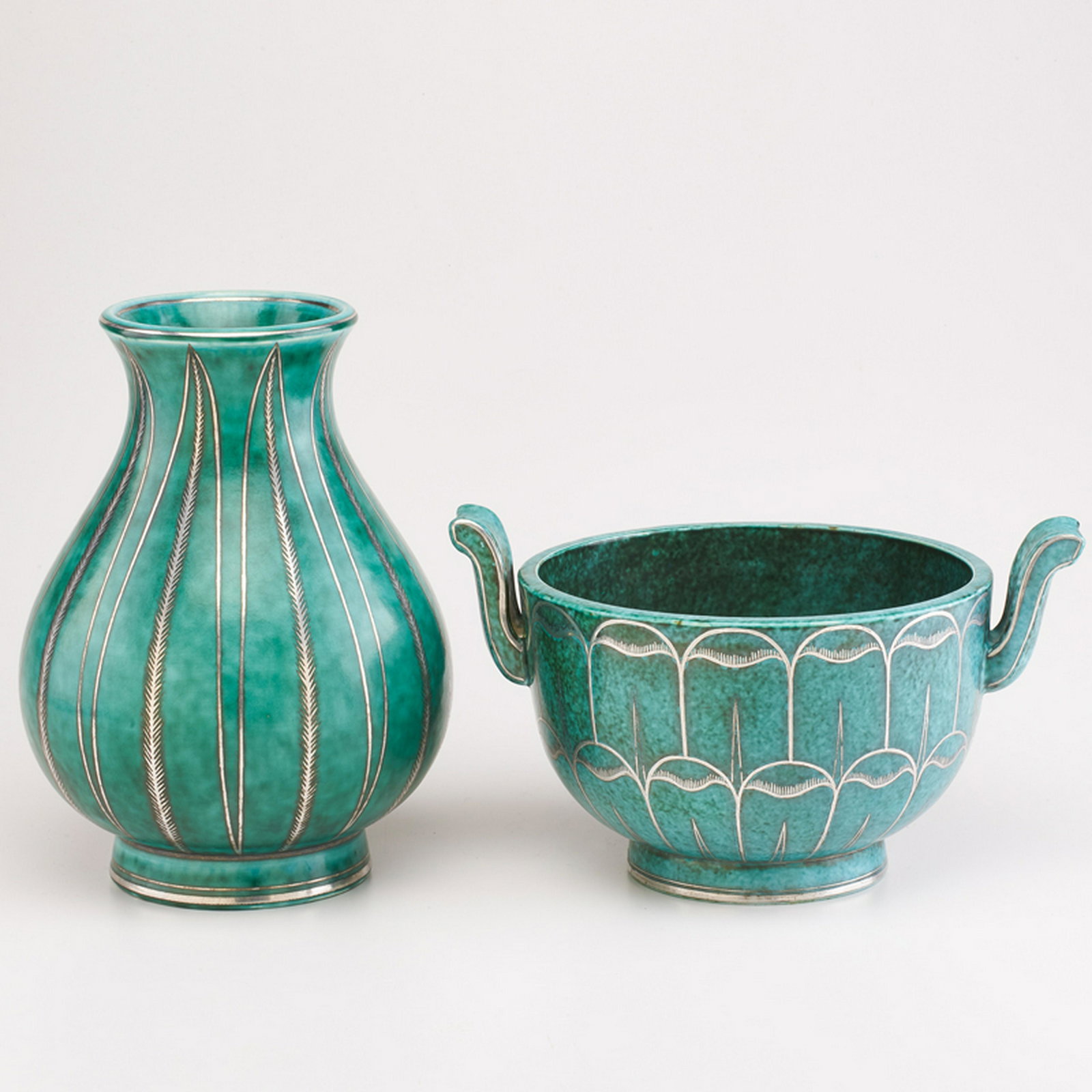 WILHELM KAGE (1889 - 1960); GUSTAVSBERG: Two Argenta pieces, with stylized feather/leaf decoration: handled bowl, and tulip-form vase, Sweden, 1932/1939 Glazed earthenware, electroplated silver Each marked HANDDREJAD/ARGENTA/1070 II/GUSTAVSB