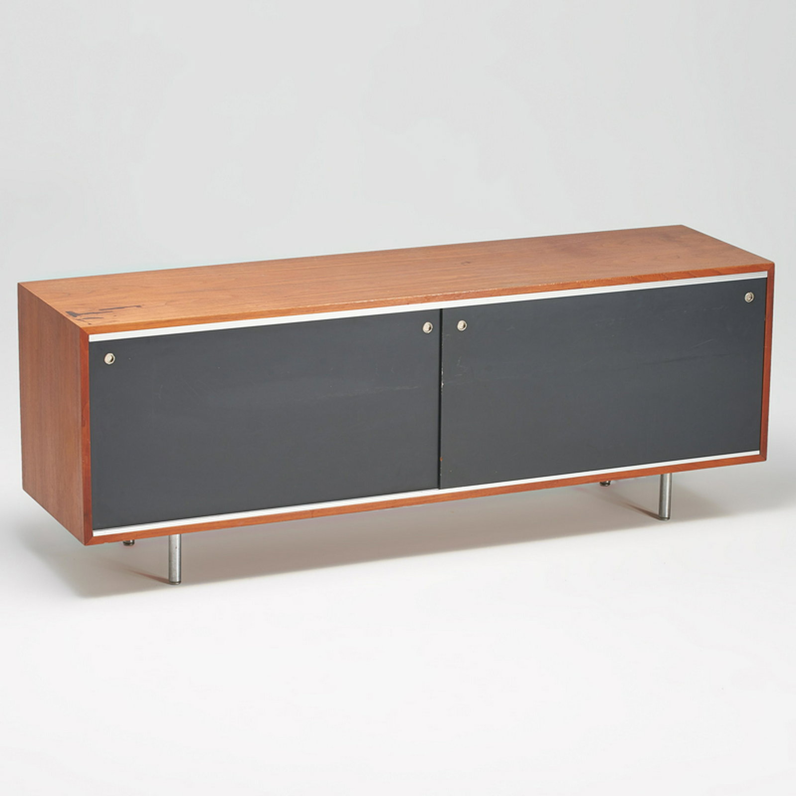 GEORGE NELSON; HERMAN MILLER: Sliding door cabinet, Zealand, MI, 1960s Brushed steel, enameled masonite, walnut Unmarked 27" x 74 1/2" x 19"