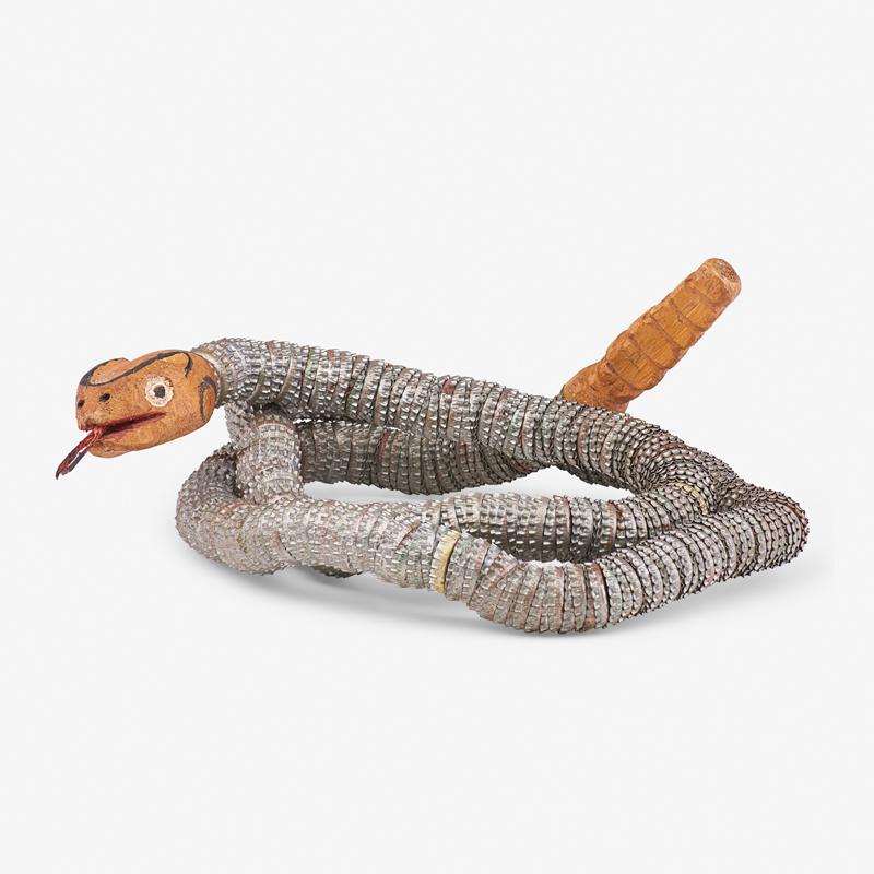 FELIPE BENITO ARCHULETA (American, 1910-1991) Attr: Long tongued snake with carved wood head and tail and bottle cap body Likely an effaced signature under jaw 12" x 12" coiled, 62" long Felipe Benito Archuleta, one of the best known and most sought af