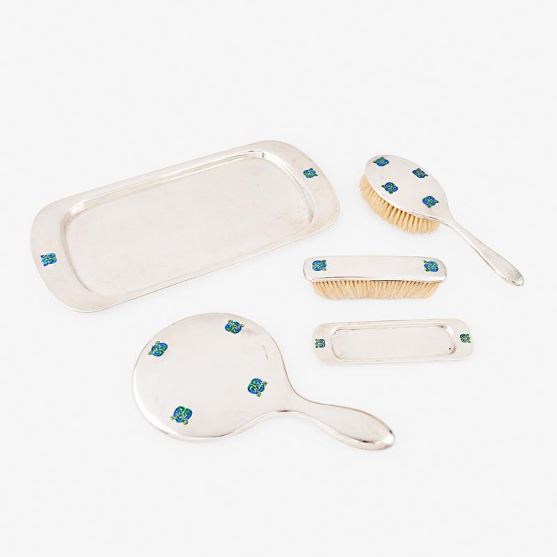 LIBERTY & CO. CYMRIC & ENAMEL DRESSER SET: Five: Each with blue and green enamel decoration, includes hand mirror, tray, two brushes and a small brush tray, Birmingham, England, 1905 Marked Tray: 7 3/4" x 15", 21 ozt (weighable)
