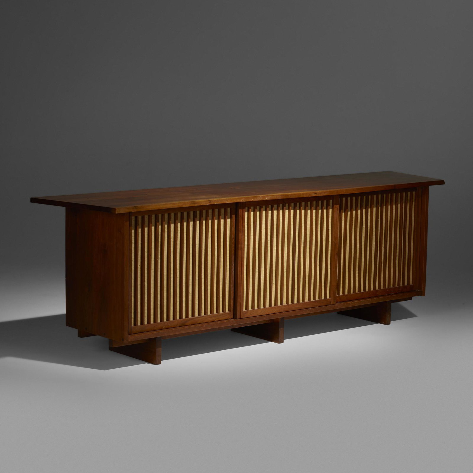 George Nakashima, Triple Sliding Door Cabinet: George Nakashima Triple Sliding Door Cabinet Nakashima Studio USA, 1967 American black walnut, pandanus cloth 32.25 h × 100.25 w × 22.25 d in (82 × 255 × 57 cm) Cabinet