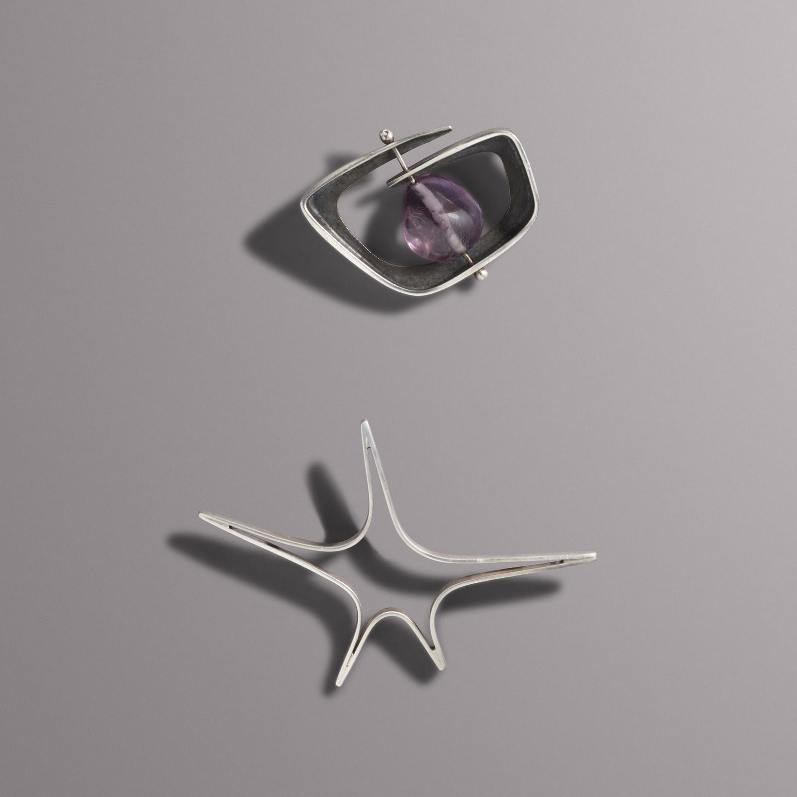 Ed Wiener, Two silver brooches: Ed Wiener Two silver brooches Sterling silver Star brooch: unsigned; Amethyst brooch: stamped Wiener Silver brooch: 3 1/16 x 2 1/8 ins; Amethyst brooch: 1 5/8 x 1 3/8 ins; Gross weight 18.4 dwts