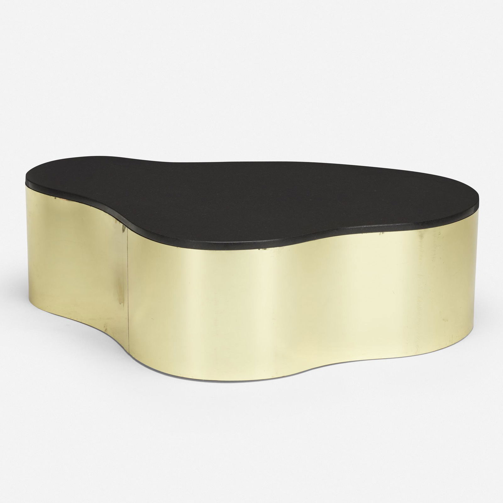 In the manner of Karl Springer, freeform coffee table: In the manner of Karl Springer freeform coffee table USA, c. 1970brass, granite13.75 h × 48.5 w × 34.25 d in (35 × 123 × 87 cm) please note: this work is loca