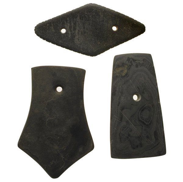 THREE SLATE GORGETS, NORTHEAST: THREE SLATE GORGETS, NORTHEAST Woodland period banded slate pendants of various forms. (Provenance: Private collection, Pennsylvania). Good condition, minor scratches, remnants of glue from previous c