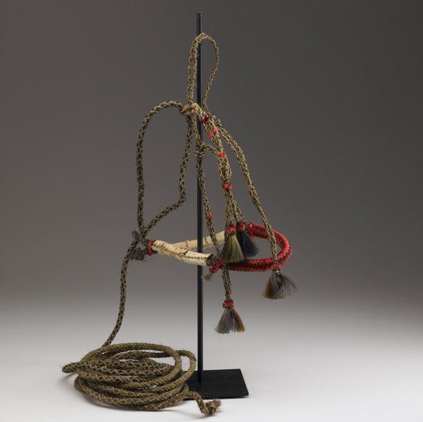 HORSE HAIR BOSAL BRIDLE, MONTANA: HORSE HAIR BOSAL BRIDLE, MONTANA Braided multicolor horse hair reins with bosal nose band decorated with wool in shades of red and brown, and horse hair tassles, c.1915. Prison-made, likely at a Monta