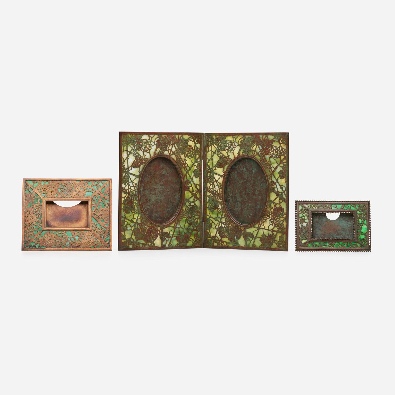 Tiffany Studios, Grapevine frames, collection of three: Tiffany Studios Grapevine frames, collection of three USA, c. 1910 patinated bronze, Favrile glass 9.75 h × 7.75 w in (25 × 20 cm) Lot is comprised of two perpetual calendar frames, mod