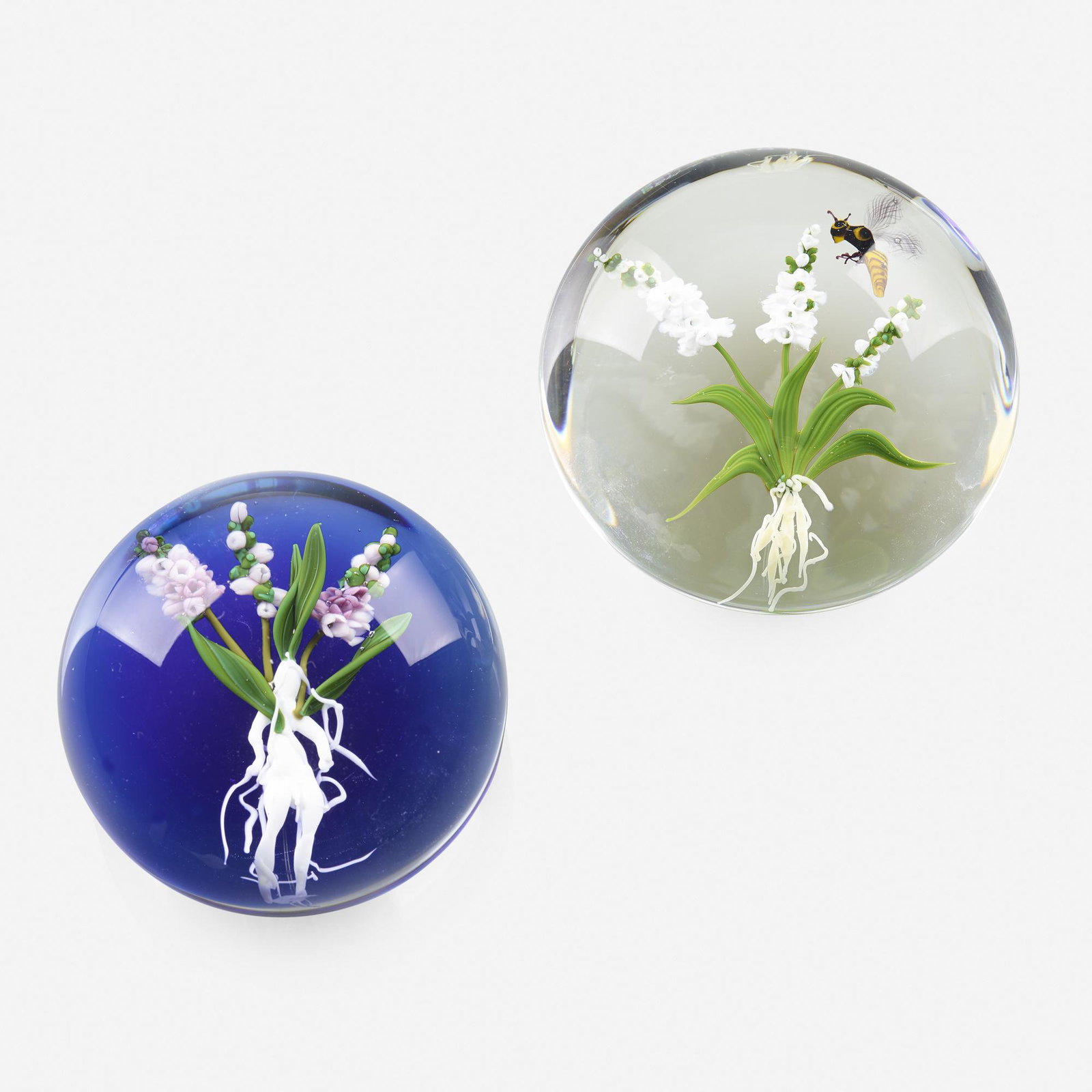 Paul Stankard, paperweights, set of two: Paul Stankard paperweights, set of two USA, 1980, 82 lampworked glass, polished clear glass 1.75 h × 3 dia in (4 × 8 cm) Works feature foxgloves, a honey bee, and a root person. Blue pa