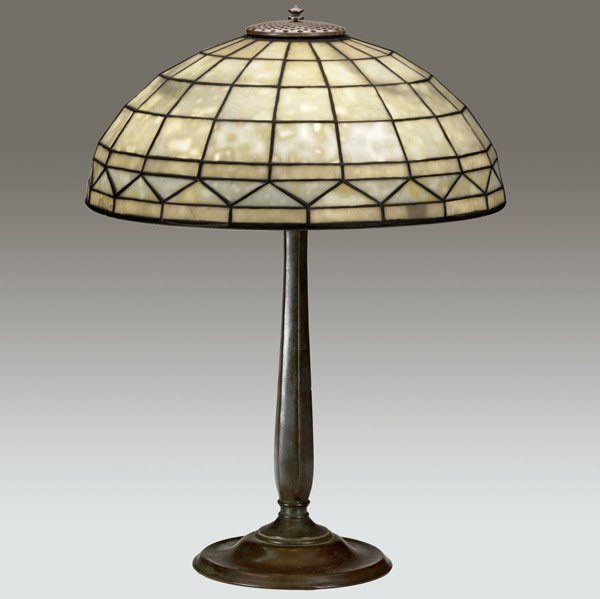 TIFFANY STUDIOS Colonial table lamp: TIFFANY STUDIOS Table lamp with a Colonial geometric shade on a three-socket bronze Library base. Fine original patina. Stamped TIFFANY STUDIOS NEW YORK, shade: 1900, base: 534. 22'' x 16''