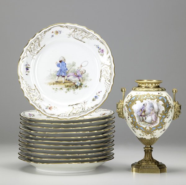 PORCELAIN GROUPING : PORCELAIN GROUPING Set of twelve Dresden-type hand-painted plates, ''Children at Play,'' along with an urn in dore mount signed Philippe, probably missing a lid, all early 20th C. Largest: 9 1/2''