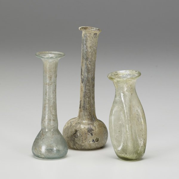 ROMAN GLASS BOTTLES : ROMAN GLASS BOTTLES Two candlestick green glass unguentaria and one smaller lobed vessel, 1st-3rd century A.D. Intact with ancient patina. Tallest: 5''