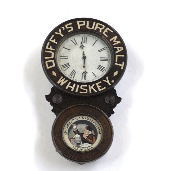 WHISKEY ADVERTISING CLOCK: WHISKEY ADVERTISING CLOCK New Haven Clock Co. wall clock with carved bezel frame and painted glass insert promoting Duffy's Pure Malt Whiskey. Some overpainting to back of original image and lettering