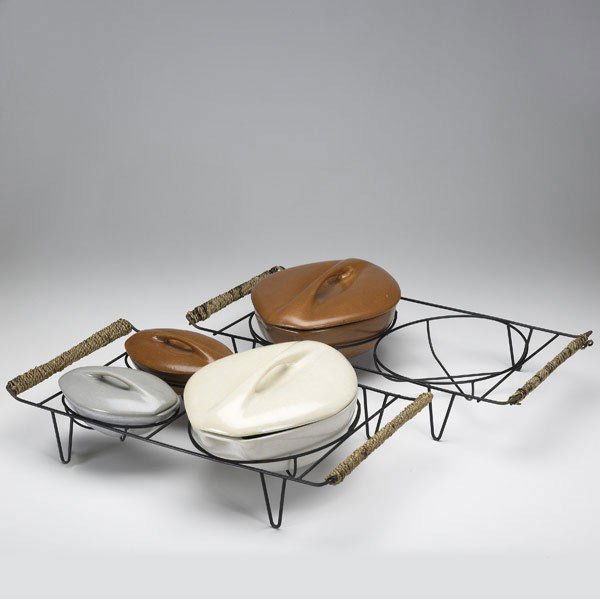 ROSEVILLE Raymor casseroles on stands: ROSEVILLE Raymor four lidded casserole dishes on original wire and rope stands. Short tight line to ivory lid, 1/2'' chip beneath large brown lid. Stamped Raymor by Roseville USA and numbered. Largest