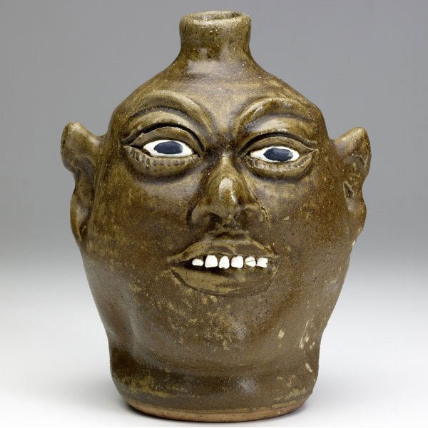 LANIER MEADERS Face jug: LANIER MEADERS Folk Art face jug with smiling expression and clay teeth, dated 1987. Signed Lanier Meaders. 9 1/2''