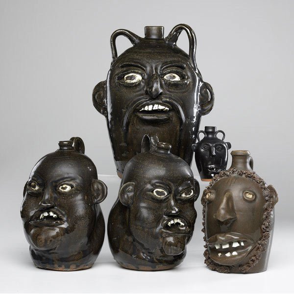 HEWELL ETC. Five face jugs: HEWELL ETC. Five Folk Art face jugs: two by Matthew Hewell, 12''; one by Chester Hewell, 13 3/4''; Seagrove by Auman with beard, 10 1/2''; and Oakland miniature, 5''. All signed.