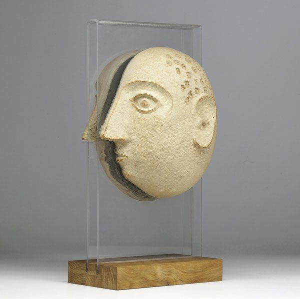 DAVID GIL Ceramic "split" head sculpture: DAVID GIL Ceramic ''split'' head sculpture with impressed numerals on skull, mounted on a lucite and wood base. Marks to interior. 19 1/4'' x 8 1/4'' x 9 1/2''