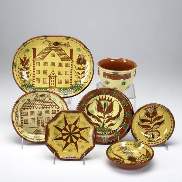 Seven pieces of James Seagraves redware pottery: Seven pieces of James Seagraves redware pottery, 20th C. Five slip-decorated bowls, a slip-decorated loaf dish and a flower pot. One is a whistle. All marked 'JCS'. Largest: 8 1/2'' x 11''