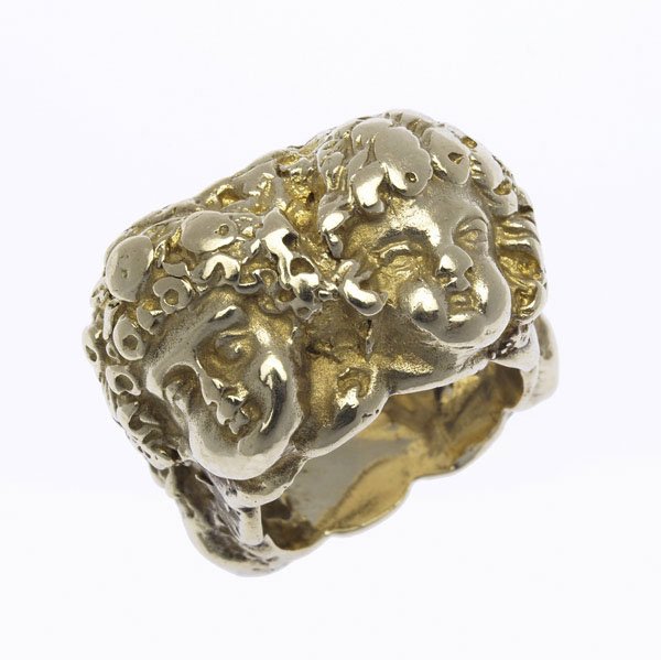 ERIC DE KOLB MODERNIST SCULPTURAL CHERUB RING : ERIC DE KOLB MODERNIST SCULPTURAL CHERUB RING 14k yg, ca. 1970. Broad band with four cherub masks in deep relief, New York City. 39.2 gs. 9/16'' x 1/4''. Size 7 1/2.
