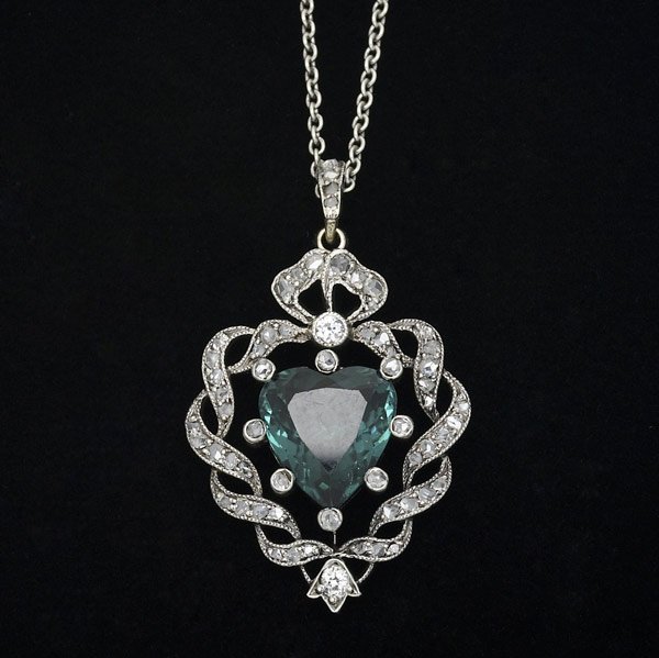 EDWARDIAN INDICOLITE & DIAMOND PENDANT : EDWARDIAN INDICOLITE & DIAMOND PENDANT Heart-shaped, deep blue tourmaline, 11mm x 11mm, and rose cut diamond ribbons in platinum-topped gold, 1 1/2''; chain with diamond-set box-clasp, 18''. 7.2 gs.