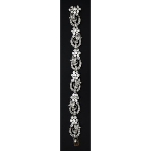 DIAMOND AND PLATINUM GARLAND BRACELET : DIAMOND AND PLATINUM GARLAND BRACELET Retailed by Tiffany & Co., ca. 1952. Designed as a continuous ribbon of floriform clusters and foliate links, the clasp set with one marquise diamond, .60 ct., an