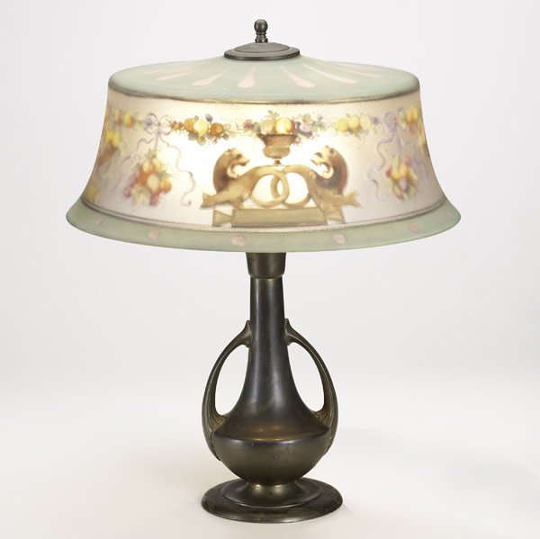 PAIRPOINT Table lamp: PAIRPOINT Table lamp reverse-painted with trophies, cartouches, and fruit on urn base Shade stamped, base unmarked 23'' x 18''