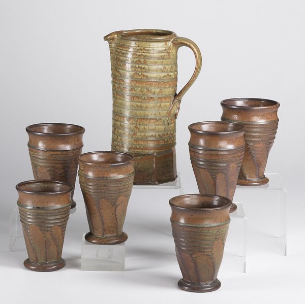VAL CUSHING STONEWARE: VAL CUSHING Stoneware pitcher and six footed beakers, 1986. All signed. Pitcher: 11'' x 7'' x 5''