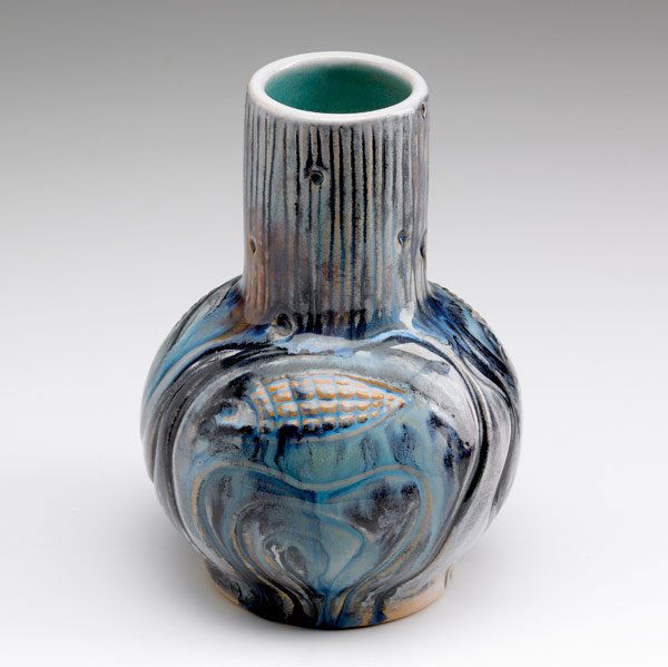 NORTH DAKOTA SCHOOL OF MINES: NORTH DAKOTA SCHOOL OF MINES Bottle-shaped vase with fish and tree-trunk pattern, covered in blue, white and black flambe glaze, the buff clay showing through. Indigo stamp. 7'' x 5''