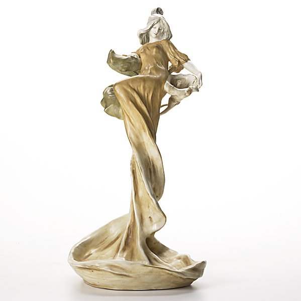 RSTK Large Amphora porcelain figurine: RIESSNER, STELLMACHER & KESSEL; Large Amphora porcelain figurine of maiden with cala lily, c. 1896; Small chip to back of sleeve and light wear to gold; Stamped AMPHORA AUSTRIA crown, IMPERIAL AMPHORA