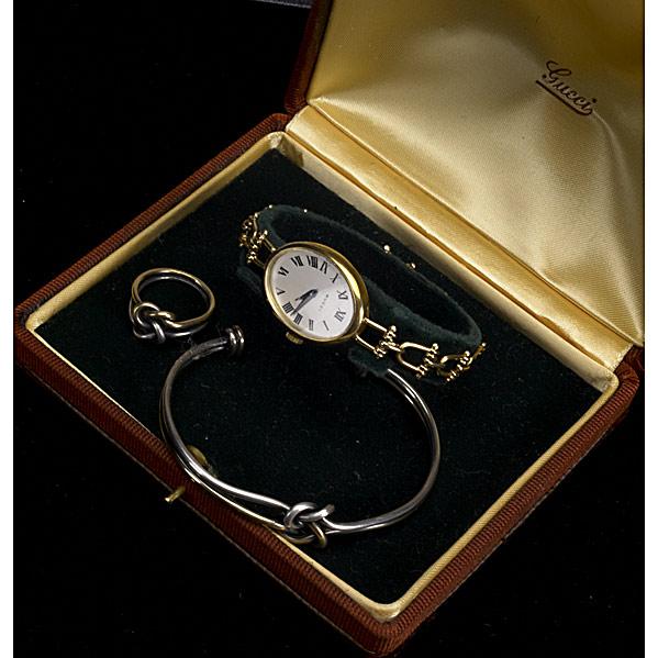GUCCI: GUCCI; Oval watch with 18k stirrup-link bracelet, 17-jewels Swiss movement, ca. 1980, in original case; 18k and sterling knot motif cuff and ring; 40 gs. GW