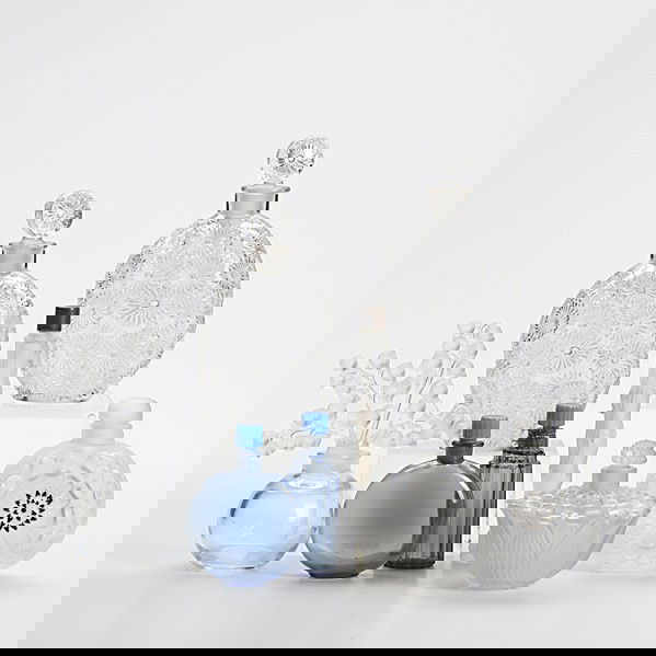 LALIQUE: LALIQUE; Eight perfume bottles: figural stopper ''Clairefontaine'', lotus form, two lilacs for Worth, ''Dahlia'', ''Magic of Lancome'' and two cobalt blue, all 20th c.; Tallest: 5 1/4''