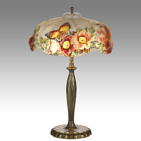 PAIRPOINT; Puffy table lamp: PAIRPOINT; Obverse- and reverse-painted glass and patinated metal Puffy table lamp with butterflies and roses; Shade signed The Pairpoint Corp, base with raised Pairpoint C 3066; 23'' x 14''