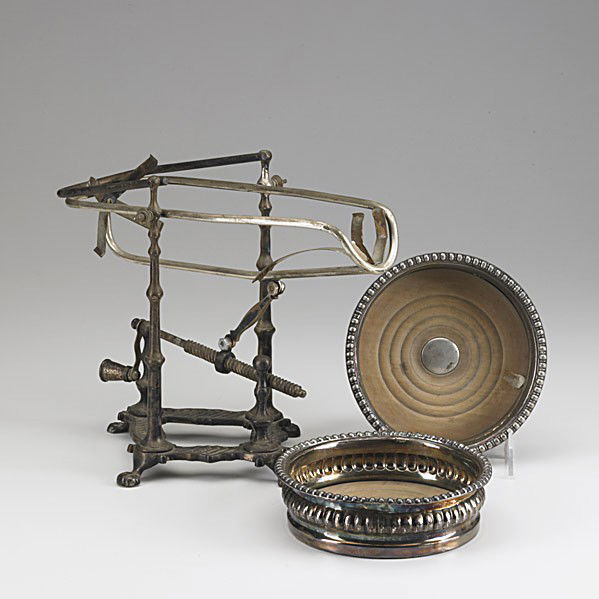 WINE ACCESSORIES: WINE ACCESSORIES; Three pieces, 19th/20th c.; Silver plate mechanical wine cradle and two silver bottle coasters with gadrooned edges; Tallest: 9 1/2''