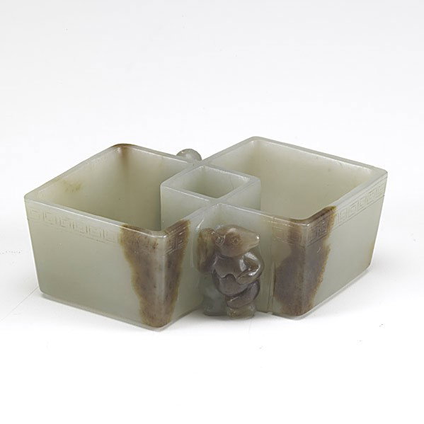 OFF WHITE AND RUSSET JADE WASHER: OFF WHITE AND RUSSET JADE WASHER; Carved with a bear on one side and a small boy on the other, 19th c.; 4 1/8''
