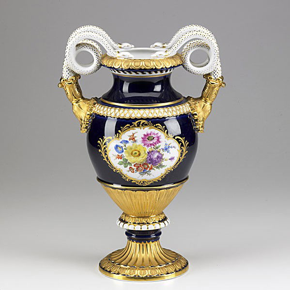 MEISSEN: MEISSEN; Porcelain urn with floral reserve, gilded highlights on cobalt ground and snake handles, early 20th c.; Crossed swords mark; 15''