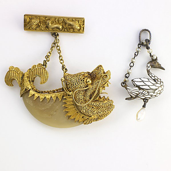 TWO FIGURAL VICTORIAN PENDANTS: TWO FIGURAL VICTORIAN PENDANTS Raj era tiger claw in Chinese 18k filigree dolphin mount suspends from an American 14k sea life motif pin; Continental Renaissance Revival enameled silver and pearl swan