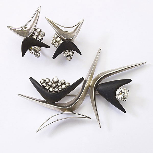 MARGARET DEPATTA DIAMOND AND WHITE GOLD SUITE: MARGARET DE PATTA DIAMOND AND WHITE GOLD SUITE Rare, sculptural 14k bright and textured gold and ebony brooch with matching screw-back, boomerang-shaped earrings set with a fine transitional cut diamo