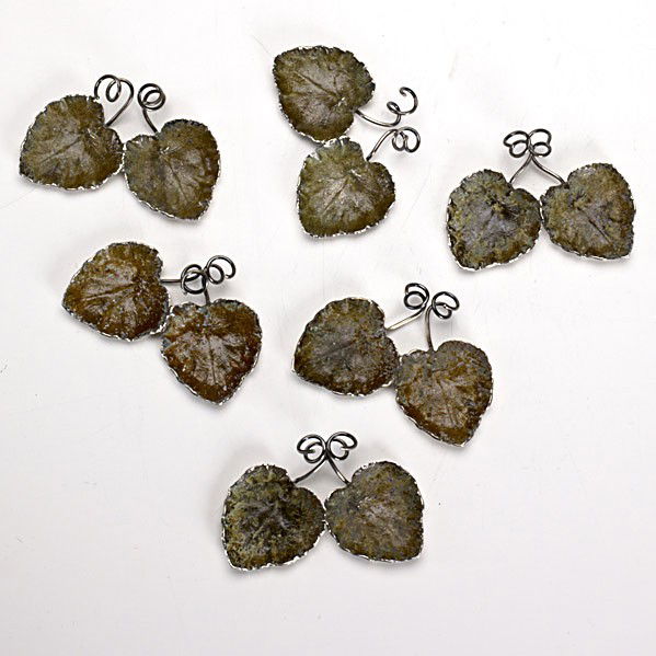 EMILIO MARAFFI/ CARTIER: EMILIO MARAFFI; CARTIER; Set of six verdigris patinated sterling leaf-form place-card holders and salt cellars, ca. 1940.; Marked; 1'' x 4'' x 2 1/2''