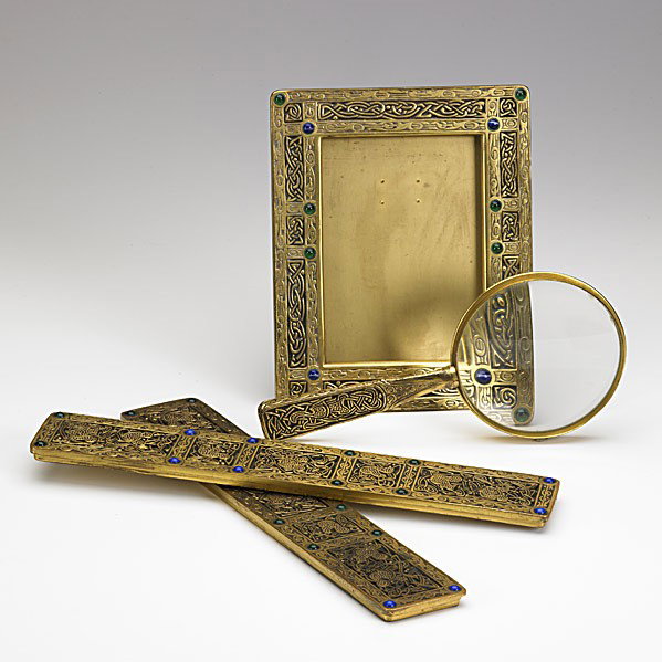 TIFFANY STUDIOS: TIFFANY STUDIOS; Ninth Century parcel-gilt desk set items: frame, blotter ends and magnifying glass; Each stamped Tiffany Studios New York; Frame 8'' x 6 1/2''