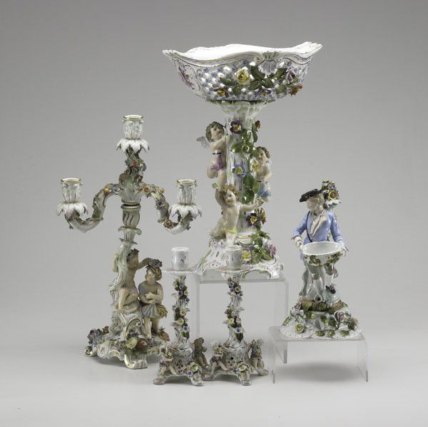 MEISSEN: MEISSEN; Four-piece porcelain garniture set decorated with children and putti, together with Dresden statue of a man holding a basket, 19th/20th c.; All marked; Tallest: 16 1/2''