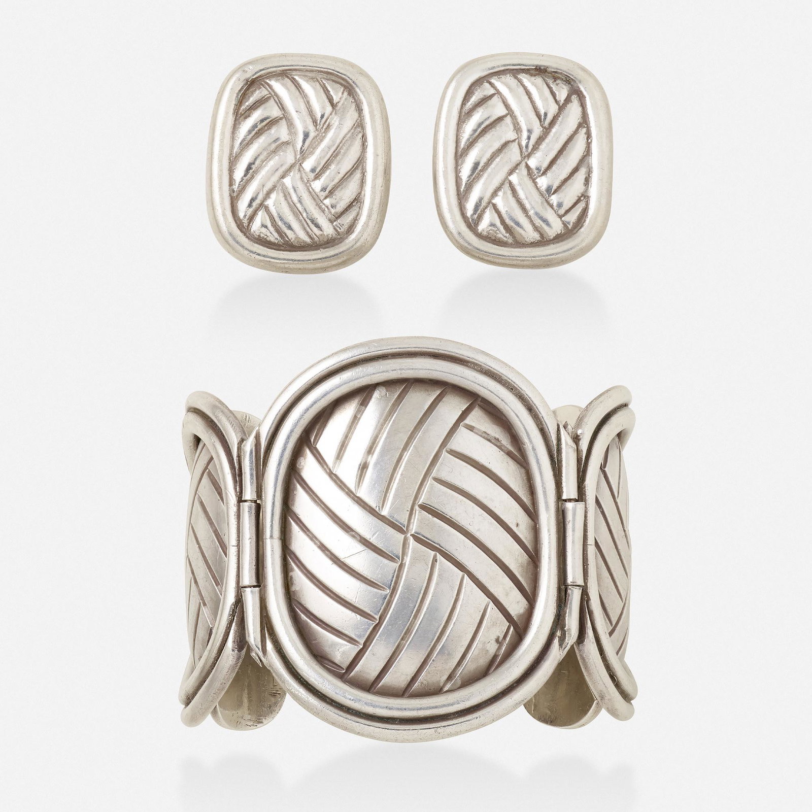 William Spratling, 'Petate' bracelet and earrings: William Spratling 'Petate' silver bracelet and earrings Of textured oval panels; 1931-1945 Silver Signed Spratling Bracelet inner circ. 6.50 in, width 2.25 in, earrings 1.25 x 1 in; Gross weight 10