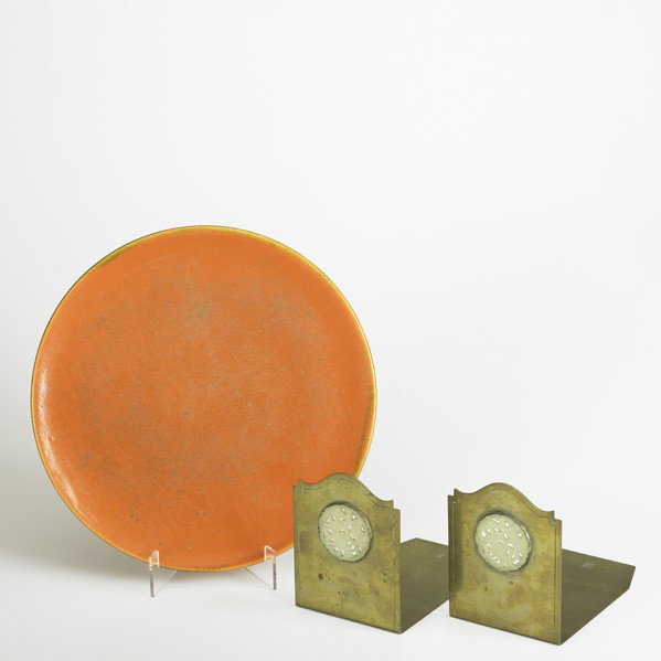 THE POTTER BENTLEY STUDIOS, ETC: THE POTTER BENTLEY STUDIOS, ETC; Pair of brass and carved jade bookends together with a ceramic orange glazed charger; Bookends stamped The Potter Bentley Studios/Cleveland/E103; Charger: 11 3/4'' dia