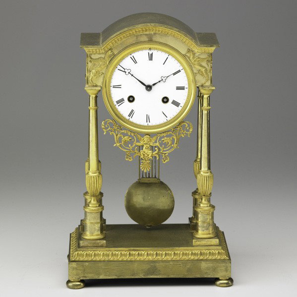 FRENCH EMPIRE PORTICO CLOCK: FRENCH EMPIRE PORTICO CLOCK; Dore bronze with porcelain dial and time and strike movement, late 19th c.; Signed JB Gibbons Paris; 14 1/2'' x 9'' x 5 3/4''