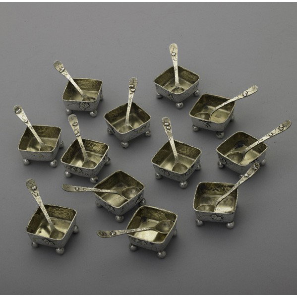 TIFFANY & CO JAPANESQUE SILVER SALT DIPS AND SPOONS: TIFFANY & CO. JAPANESQUE SILVER SALT CELLARS AND SPOONS, 1870-1874. Service for 12, square. Spot-hammered salt with ball feet, gilt interiors, with applied butterflies and chased leaves on meandering 