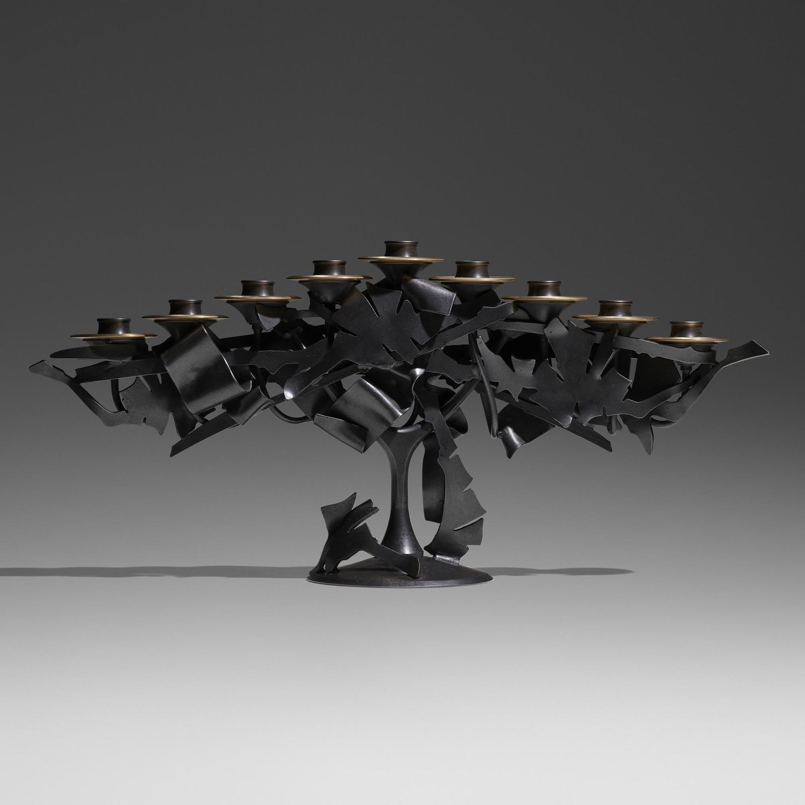 Albert Paley, Menorah: Albert Paley Menorah USA, 2013forged mild steel with a blackened patina, removable brass bobeches (collars) 10.5 h x 23 w x 6 d in (27 x 58 x 15 cm) Impressed signature and date to top of base