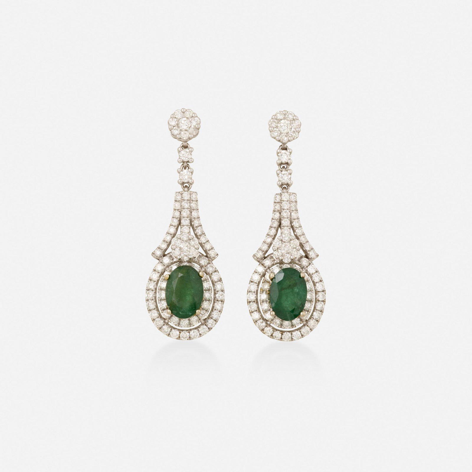 Emerald, diamond, and white gold earrings: Emerald, diamond, and white gold earrings Each set with an oval-cut emerald drop, enhanced by round brilliant-cut diamonds White and yellow gold 1.50 x 0.50 in; Gross weight 8.6 dwts This work will sh