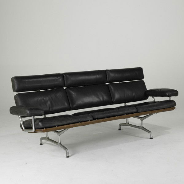 CHARLES & RAY EAMES; HERMAN MILLER: CHARLES & RAY EAMES; HERMAN MILLER; Aluminum Group sofa, USA, 1990s; Leather, polished aluminum and sculpted walnut; Herman Miller foil label; 33'' x 81'' x 32'' (Retailed by Design Within Reach)