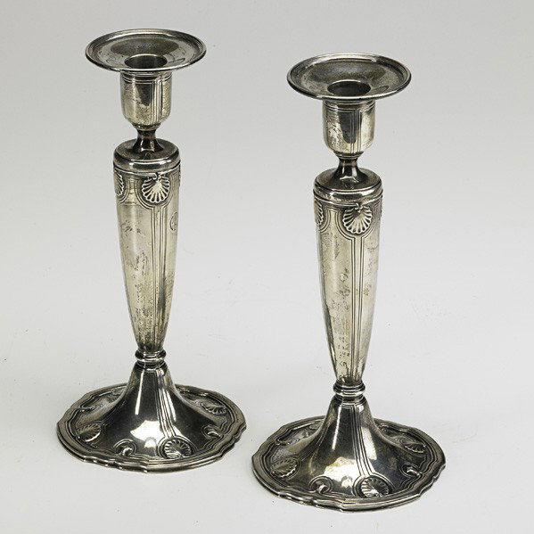 TIFFANY AND COMPANY; Pair of candlesticks: TIFFANY AND CO.; Pair of sterling silver candlesticks with seashell pattern, New York, 1911; Stamped TIFFANY & CO 18Q28 MAKERS STERLING SILVER 925-1000 M and monogrammed CFV; 12 o.t. each, 9 1/2" x 4 