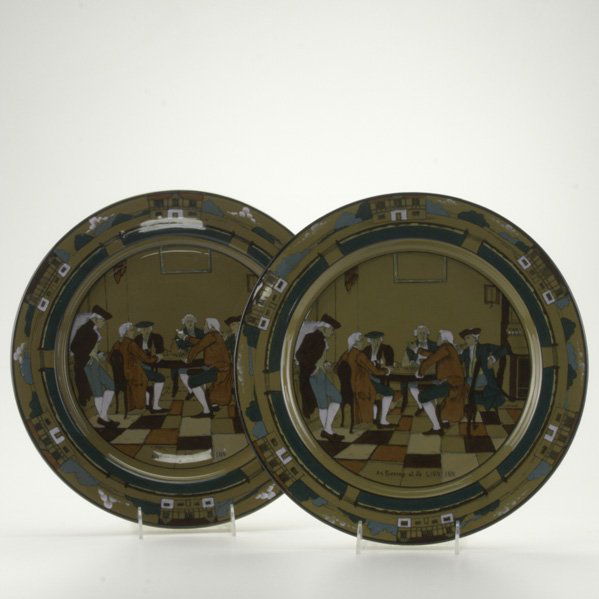 BUFFALO POTTERY; Two Deldare ware chargers decorat: BUFFALO POTTERY; Two Deldare ware chargers decorated with tavern scenes ''An Evening at Ye Lion Inn'', 20th c.; One by J. Gerhardt and one by E. Broel; Both with stamp mark; 13 1/2''