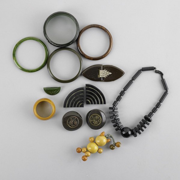 BAKELITE JEWELRY: BAKELITE JEWELRY; Thirteen pieces: Four bangle bracelets, two green, two brown; Necklace with Bakelite beads, 15''; napkin ring; Pin; Buttons; Buckle parts; Butterscotch and amber bakelite crib toy in