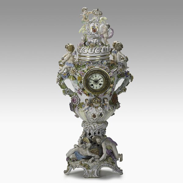 MONUMENTAL GERMAN PORCELAIN CLOCK: MONUMENTAL GERMAN PORCELAIN CLOCK; Cupid and floral reliefs, French time and strike movement, 19th c.; Repairs and restoration; 33 1/2'' x 16'' x 14 1/2''