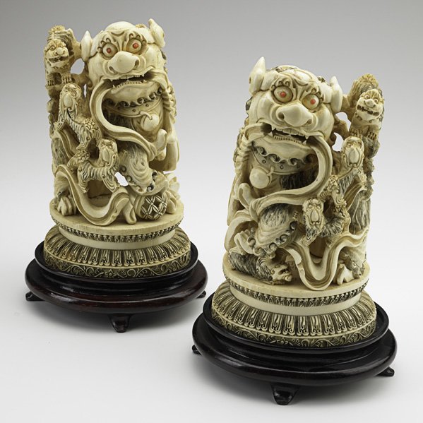 PAIR OF CHINESE IVORY FOO DOGS: PAIR OF CHINESE IVORY FOO DOGS; Coral eyes, 19th/20th c.; Signed; 8 1/2'' x 5'' x 4 1/2'' Note: International bids and bids issuing from the State of California may be subject to laws that forbid the 